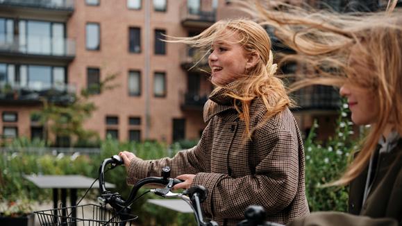 Två unga tjejkompisar med cyklar