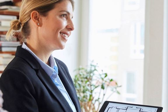 Mäklare som visar en planlösning på en ipad