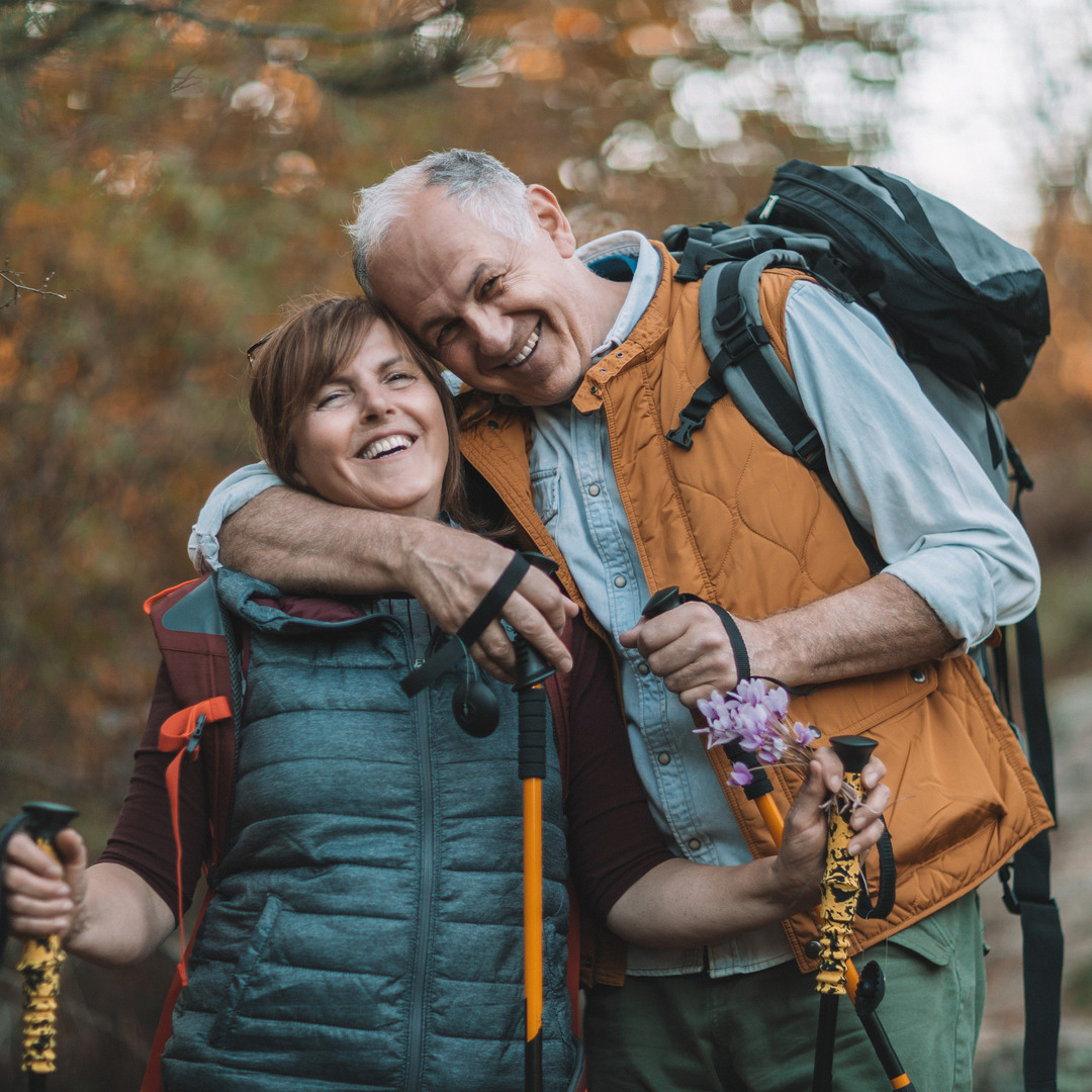 Man och kvinna är ute och vandrar med stavar