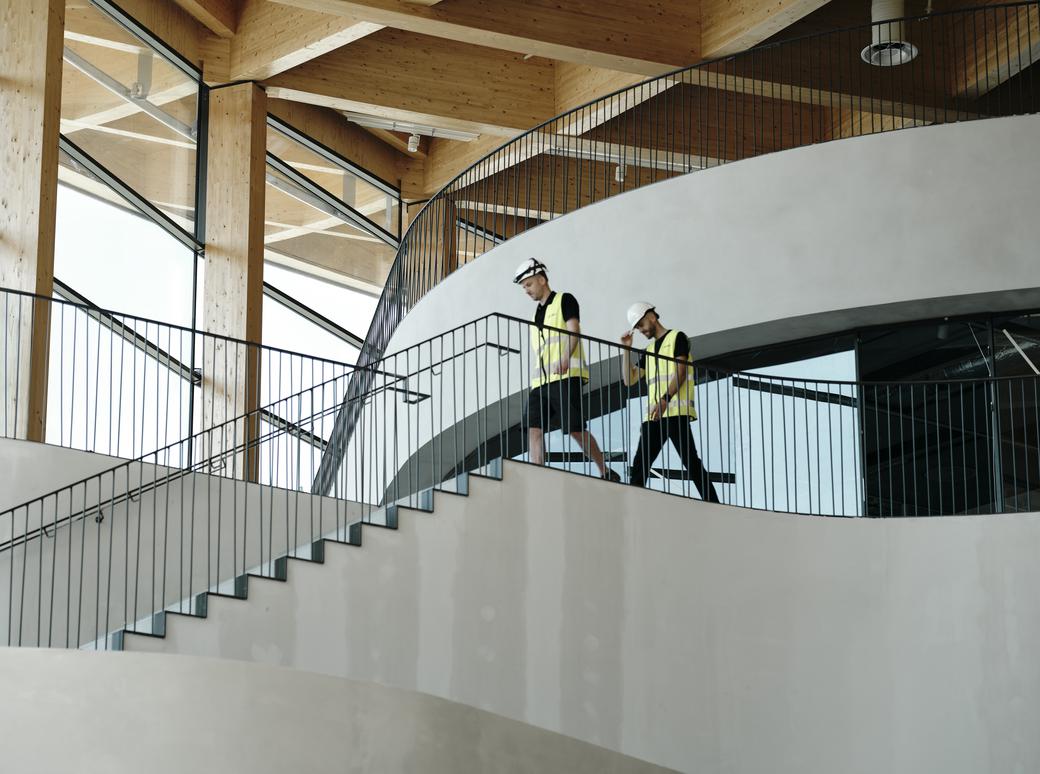 Ett trapphus i glas sett underifrån med ljuskäglor hängandes i en formation som skapar en vacker abstrakt form.