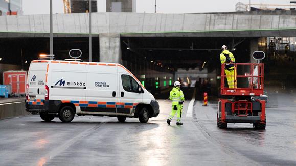 Servicebil och lyftkran framför infarten till en vägtunnel.