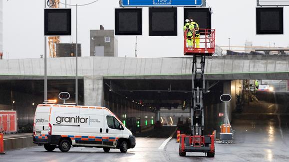 Servicebil och lyftkran framför infarten till en vägtunnel.