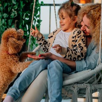 Mamma, pojke och morfar i en trädgård