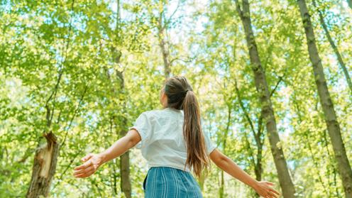 Tjej går runt i en skog