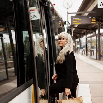 Äldre kvinna kliver på ett tåg