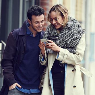 Man och kvinna som tittar i en mobiltelefon