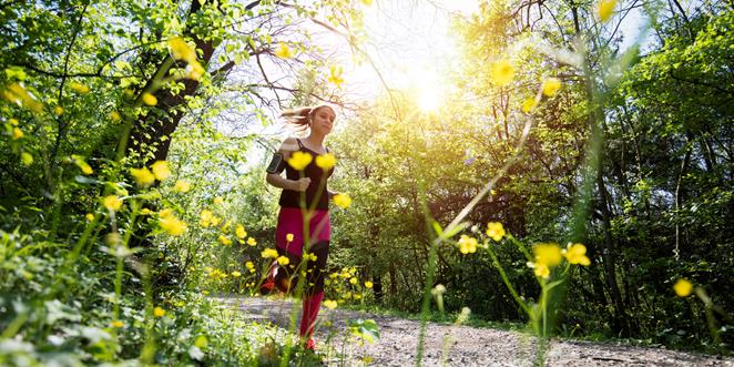 Kvinna joggar i en skog